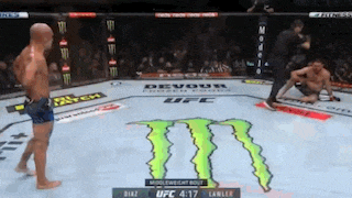 two men are fighting in a ufc ring with a monster energy logo on the ground .