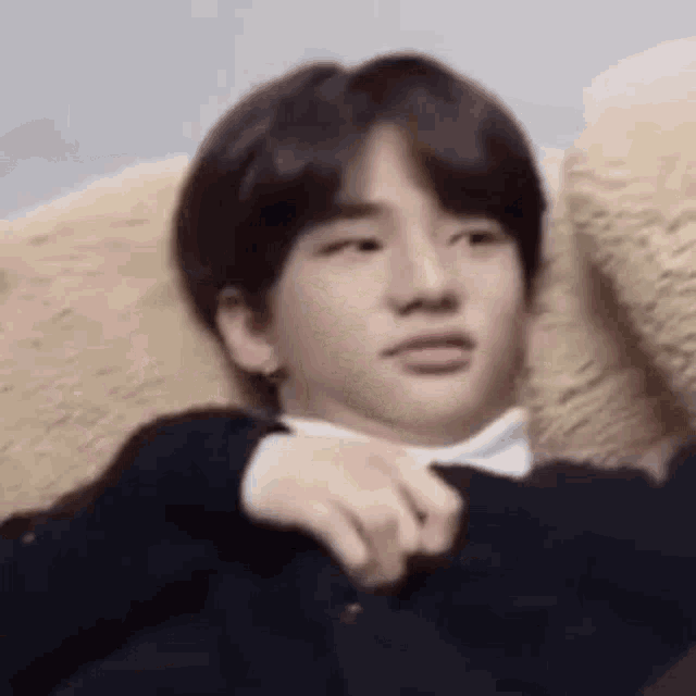 a young man is laying on a couch with his hand on his chest .