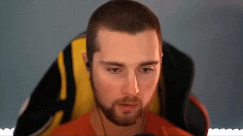 a man with a beard is sitting in a chair with headphones on .