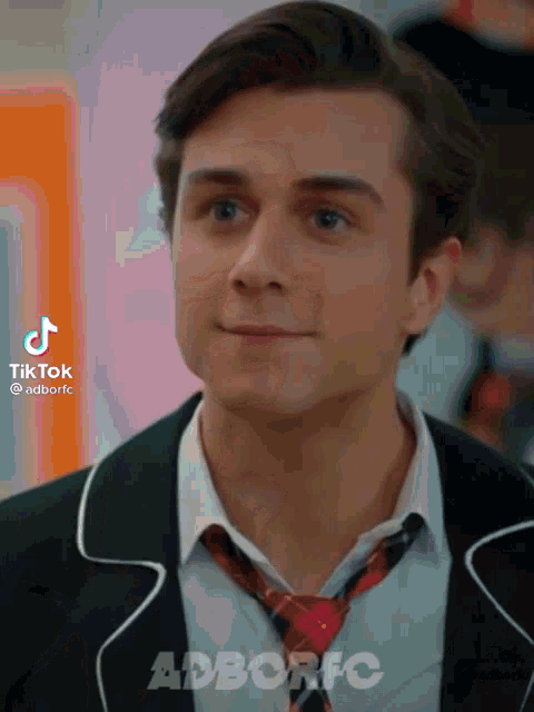 a young man wearing a suit and tie with tiktok written on the bottom right