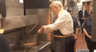 a man in a white shirt and apron is cooking in a kitchen .