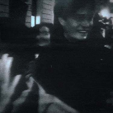 a black and white photo of a group of people dancing in a dark room
