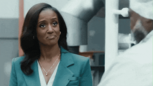 a woman in a blue suit is looking at a man in a white shirt