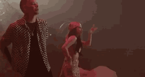 a man and a woman are dancing together on a stage in a dark room .