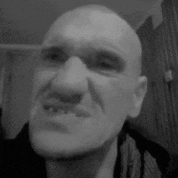 a black and white photo of a man with a missing tooth