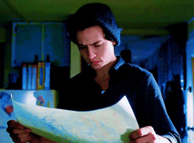 a man in a beanie is reading a map