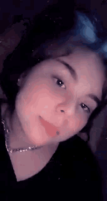 a close up of a woman 's face with a necklace on .