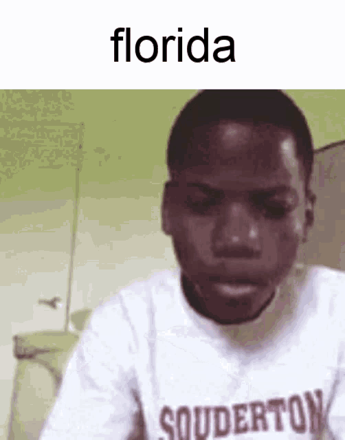 a young man wearing a florida sweatshirt is making a funny face .