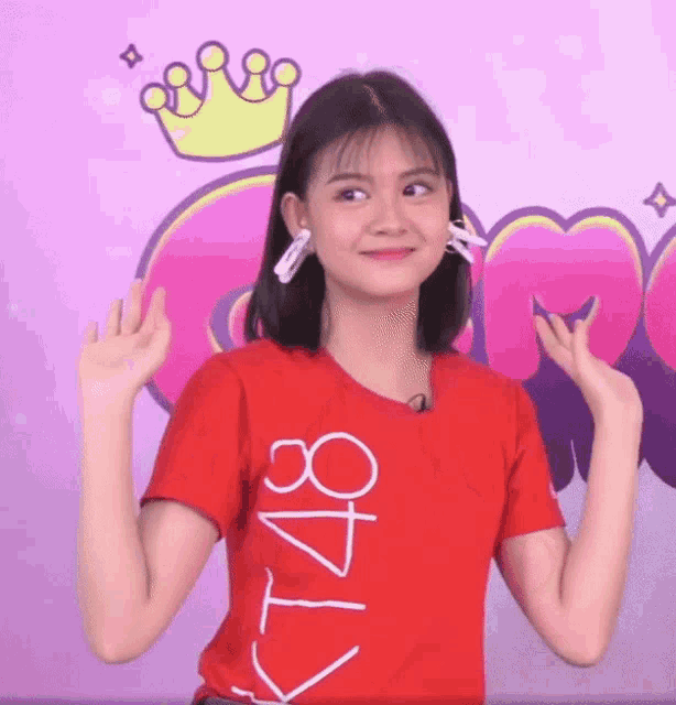 a girl wearing a red shirt with kt48 written on it