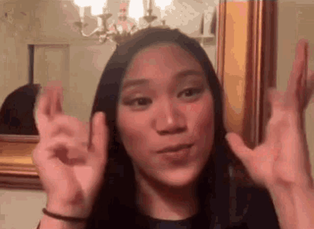a woman in front of a mirror is making an ok sign