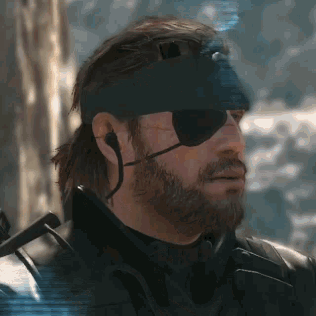 a man with a beard wearing a blindfold and a headband