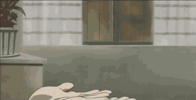 a close up of a person 's hands in a room with a window in the background .