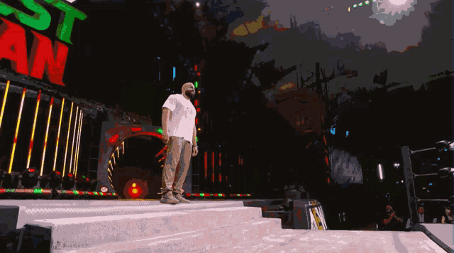 a man stands on a stage in front of a sign that says rasta