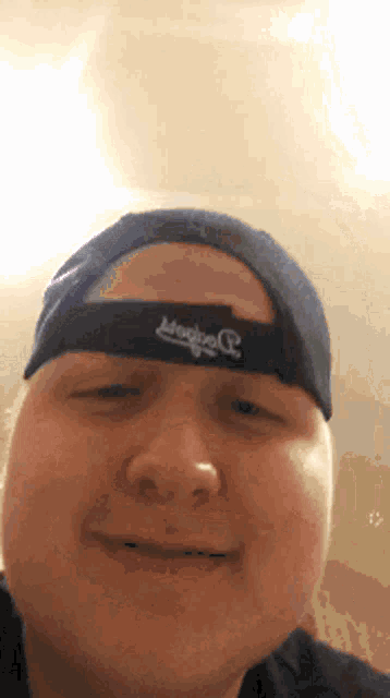 a man wearing a dodgers hat looks at the camera