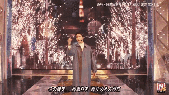 a man in a trench coat stands on a stage in front of a screen that says secret romance