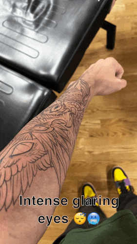 a tattoo on a man 's arm with the words intense glaring eyes