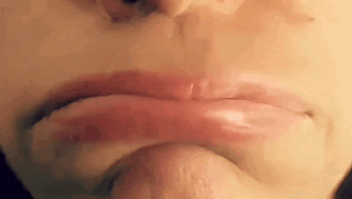 a close up of a person 's mouth with a slight smirk on it .