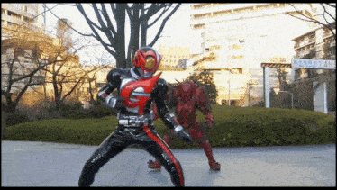 a man in a masked rider costume is standing next to another man in a red costume