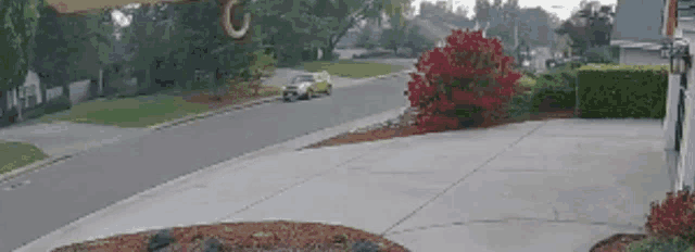 a car is driving down a residential street in a residential neighborhood .