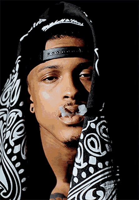 a man wearing a bandana and a hat with the word mitchell and ness on it