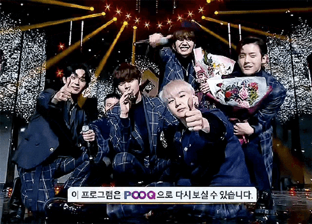 a group of young men are posing for a photo with a sign that says pooq