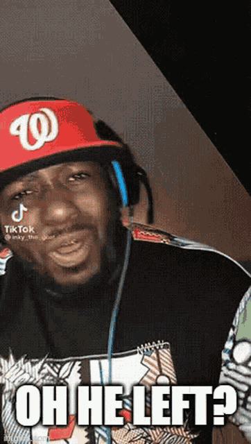 a man wearing headphones and a red hat is making a funny face .