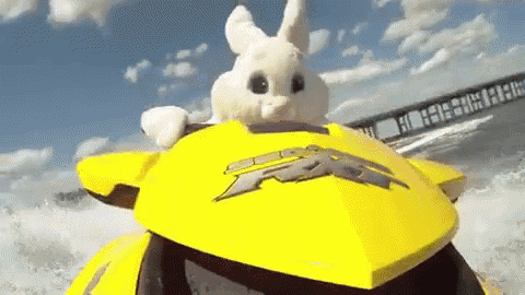 a stuffed bunny is riding a yellow jet ski in the ocean