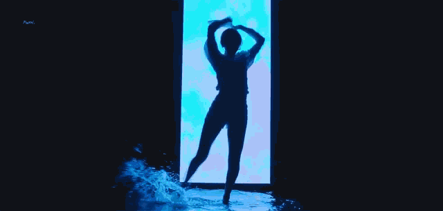 a silhouette of a woman dancing in front of a blue background
