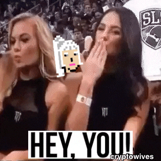 two women are sitting next to each other in a stadium and one of them is covering her mouth .