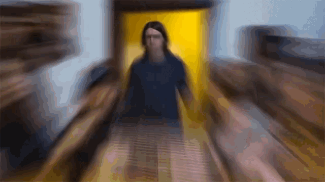a blurry picture of a man walking down a hallway