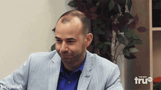 a man wearing a suit and a blue shirt is on a tv show called the new tru channel