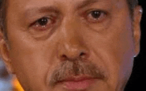a close up of a man 's face with a mustache and tears coming out of his eyes .
