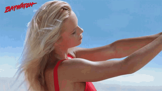 a woman in a red bikini with the word baywatch on the bottom right