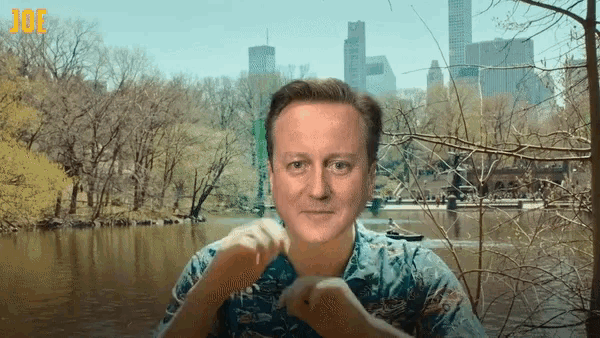 a man in a hawaiian shirt stands in front of a lake with the word joe visible