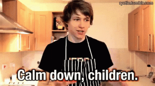 a man in an apron is standing in a kitchen and says calm down children .