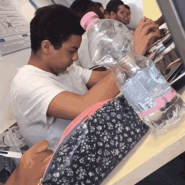 a boy is pouring water into a plastic bottle that says " seltzer " on the label
