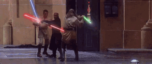 two men are fighting with lightsabers in front of a building with a green light coming out of it .