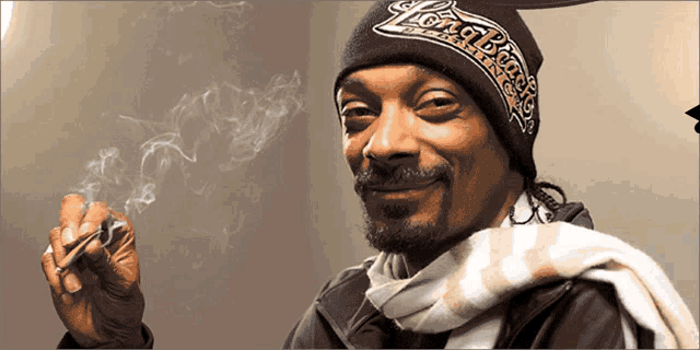 snoop dogg is wearing a long bomb hat and smoking a cigarette