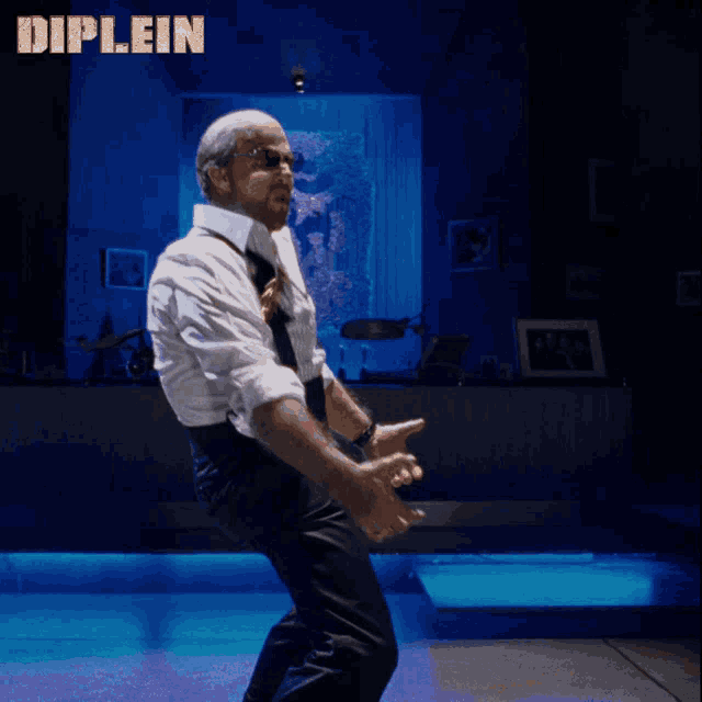a man in a white shirt and tie is dancing in front of a sign that says diplein