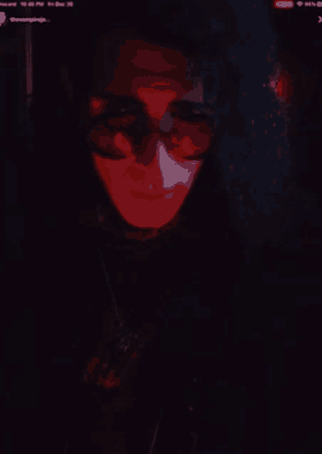 a close up of a person 's face with a red light behind them
