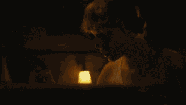 a close up of a person looking at a glowing object in the dark .