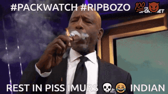 a man in a suit and tie is smoking a cigar with the caption #packwatch #ripbozo rest in piss murs indian
