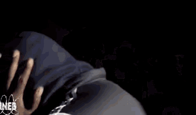 a person is covering their face with their hands while wearing a hooded jacket .