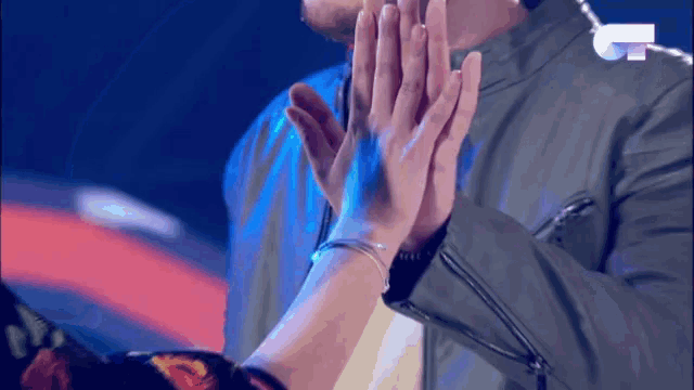 a man and a woman are giving each other a high five on a stage
