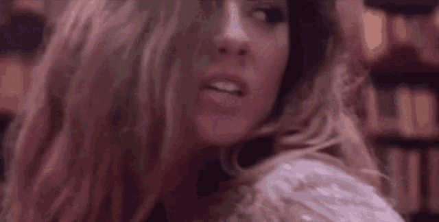 a close up of a woman 's face with her mouth open and her hair blowing in the wind .