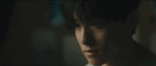 a close up of a person 's face with a dark background .