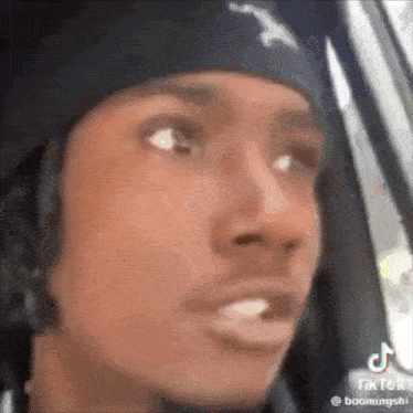 a close up of a person 's face in a car wearing a beanie .