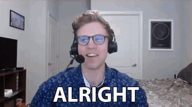 a man wearing headphones and glasses is talking on a video call while saying `` alright '' .