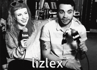 a man and a woman are sitting next to each other and the woman is holding a microphone that says lizlex