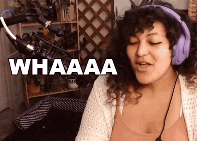 a woman wearing headphones is sitting in front of a microphone .
